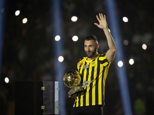 La nouvelle recrue d'Al-Ittihad, Karim Benzema, salue les fans alors qu'il tient le trophée du Ballon d'Or lors de sa présentation le 7 juin 2023.