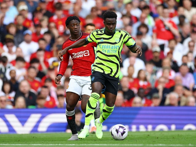 Bukayo Saka d'Arsenal en action avec Kobbie Mainoo de Manchester United le 12 mai 2024
