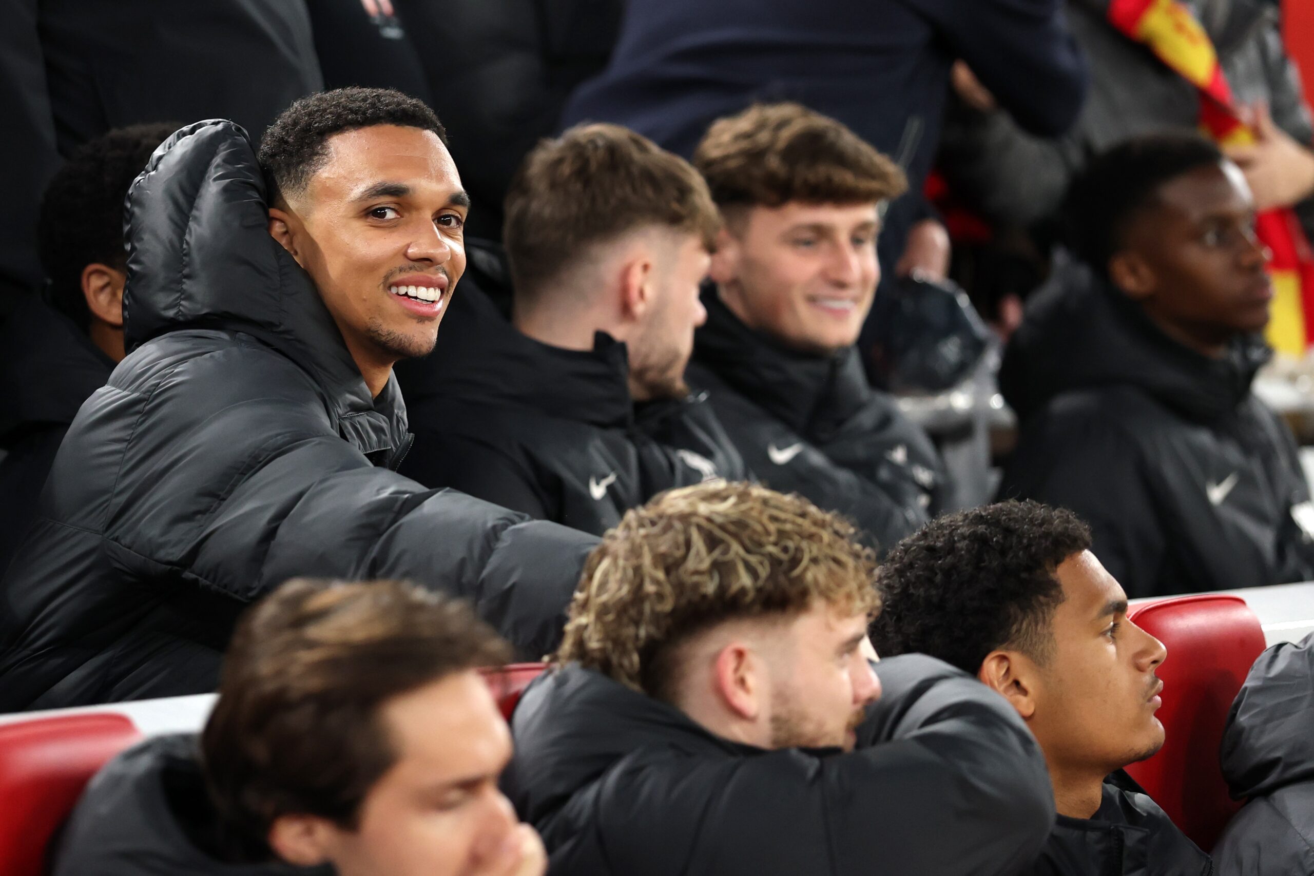 Trent Alexander-Arnold smiles on Liverpool bench.