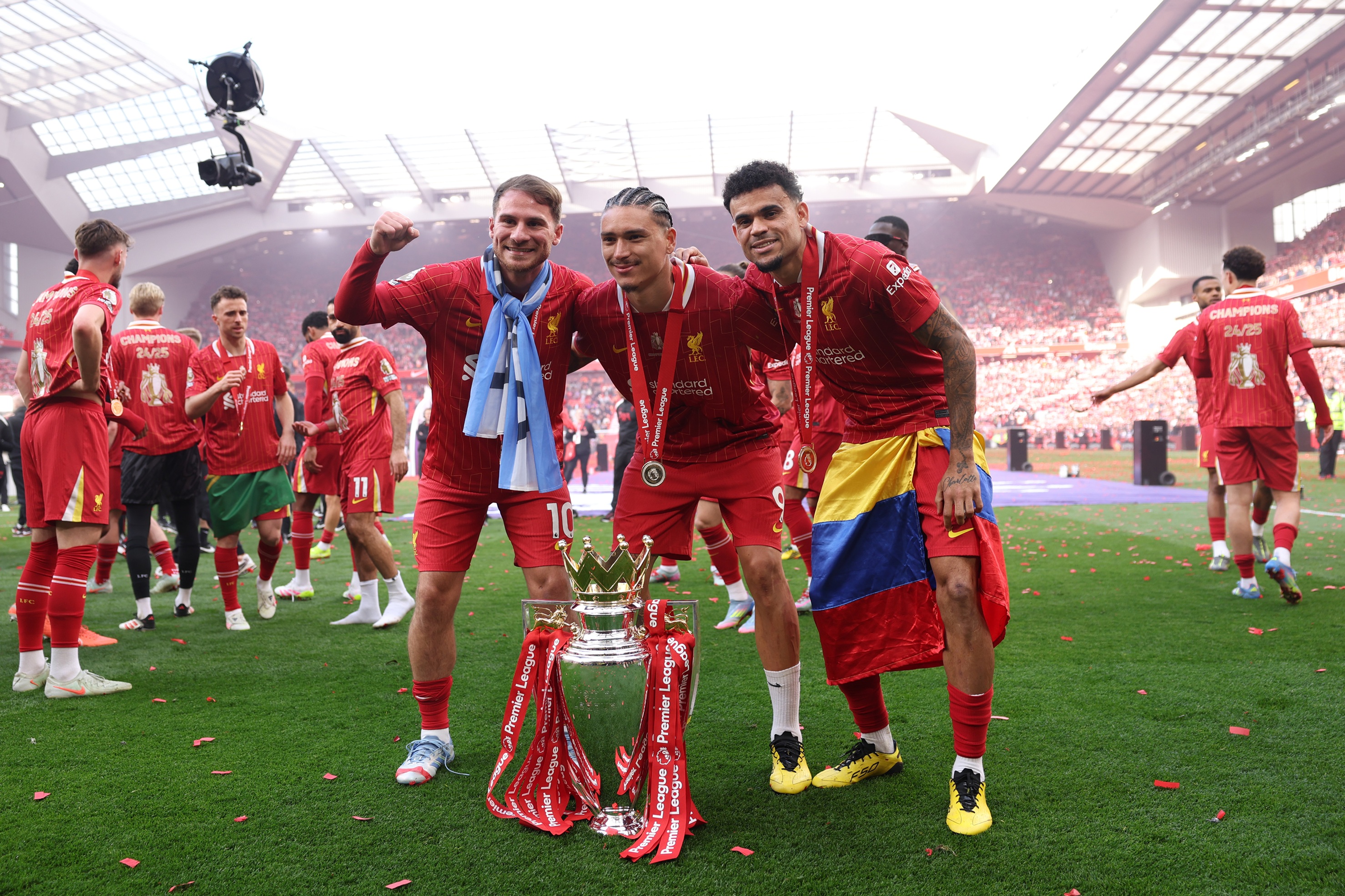 Luis Diaz, Darwin Nunez et Alexis Mac Allister célèbrent devant le trophée de la Premier League.