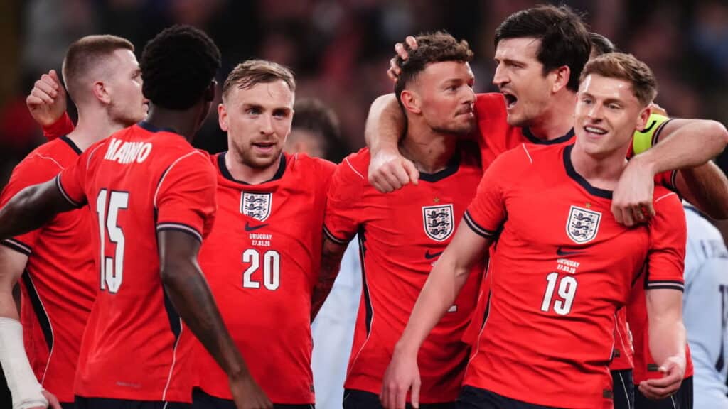 Ben White célèbre un but pour l'équipe nationale de football d'Angleterre tout en étant embrassé par ses coéquipiers en chemise rouge