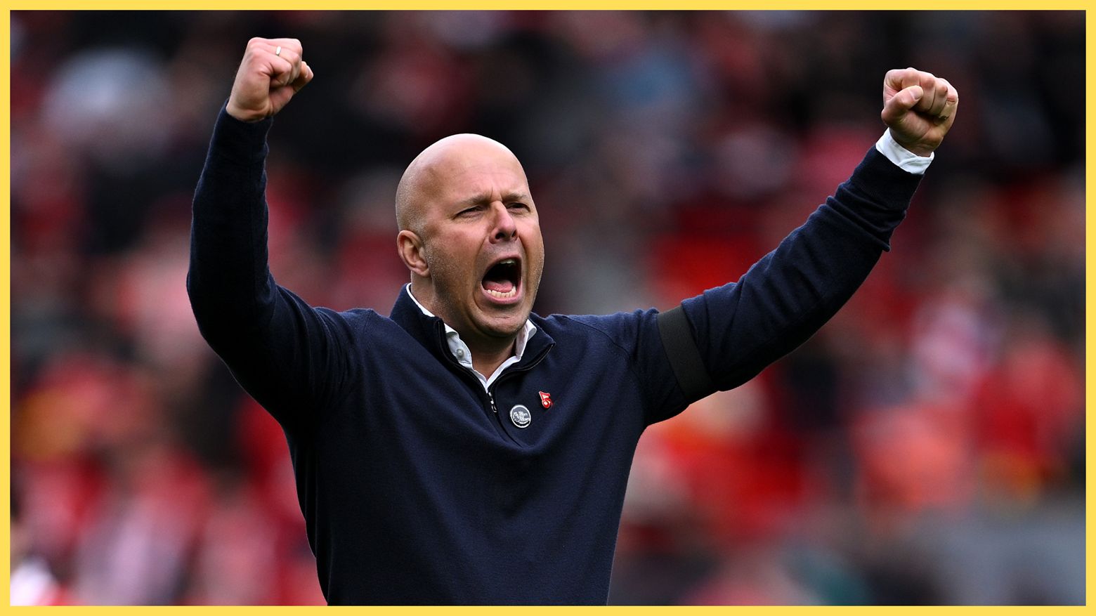 Arne Slot lève les bras pour célébrer.
