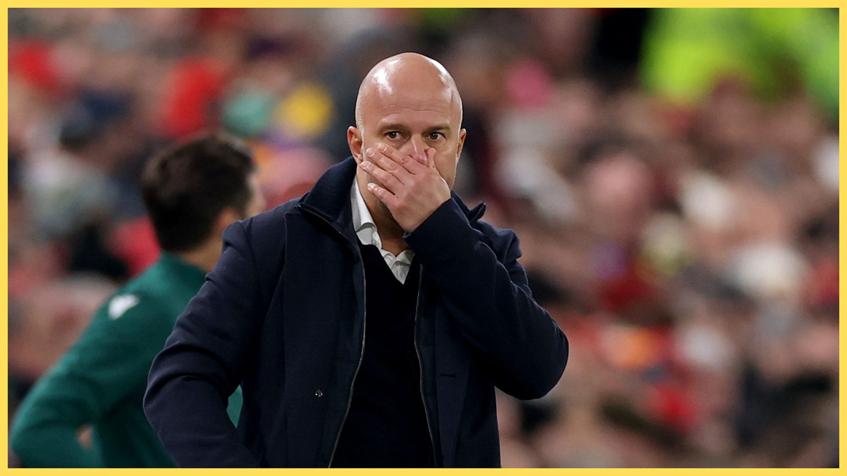 Arne Slot covers his mouth with his hand during Liverpool game.