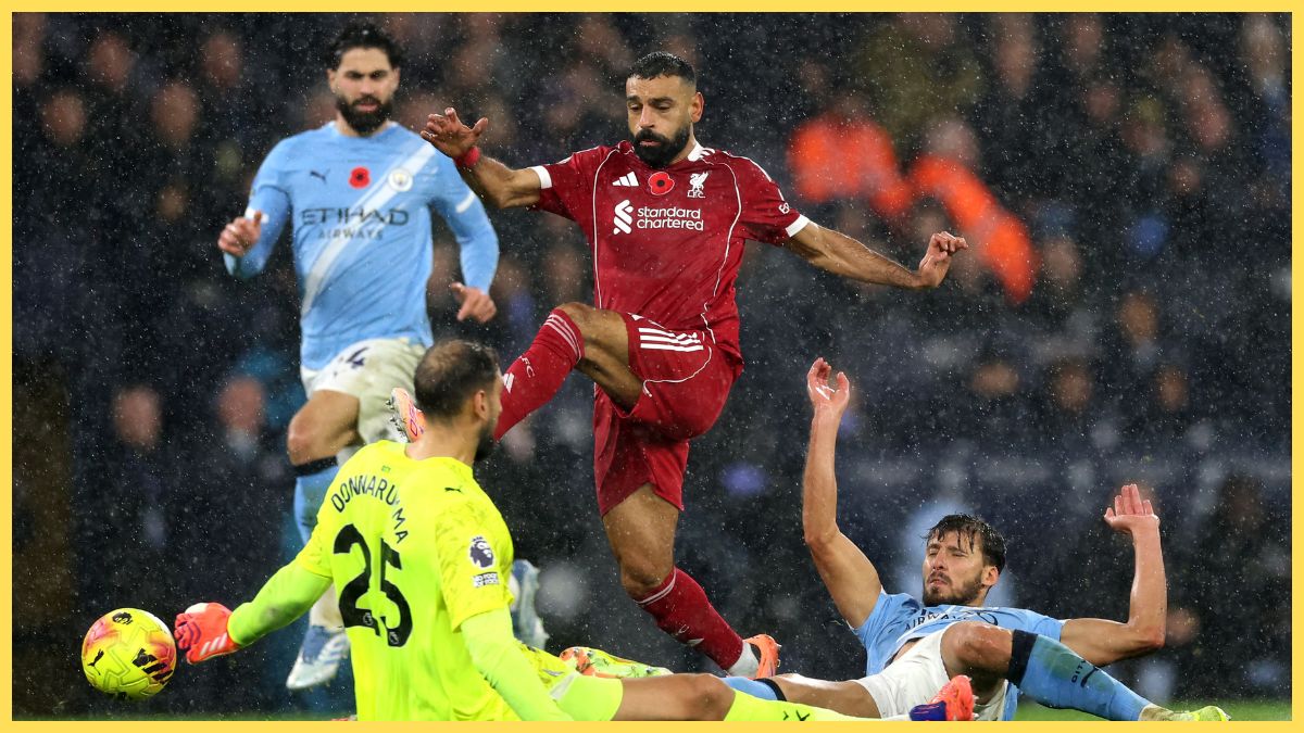 Mohamed Salah of Liverpool is challenged by Ruben Dias and Gianluigi Donnarumma of Manchester City during the Premier League match between Manchester City and Liverpool at Etihad Stadium