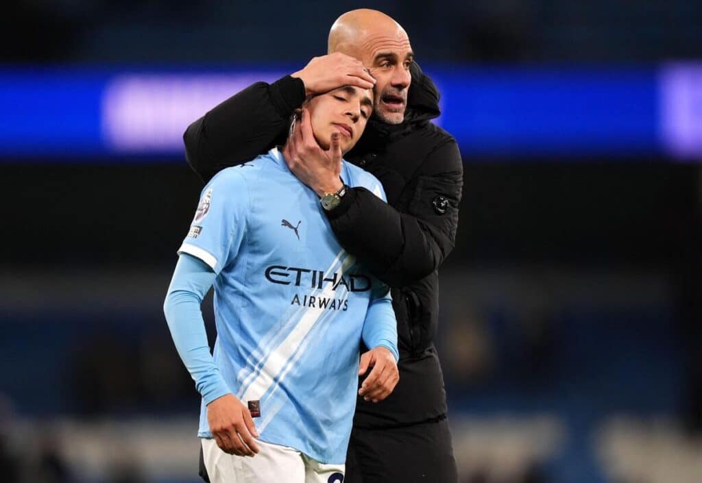 Le manager de Manchester City, Pep Guardiola, fait un câlin à Rico Lewis