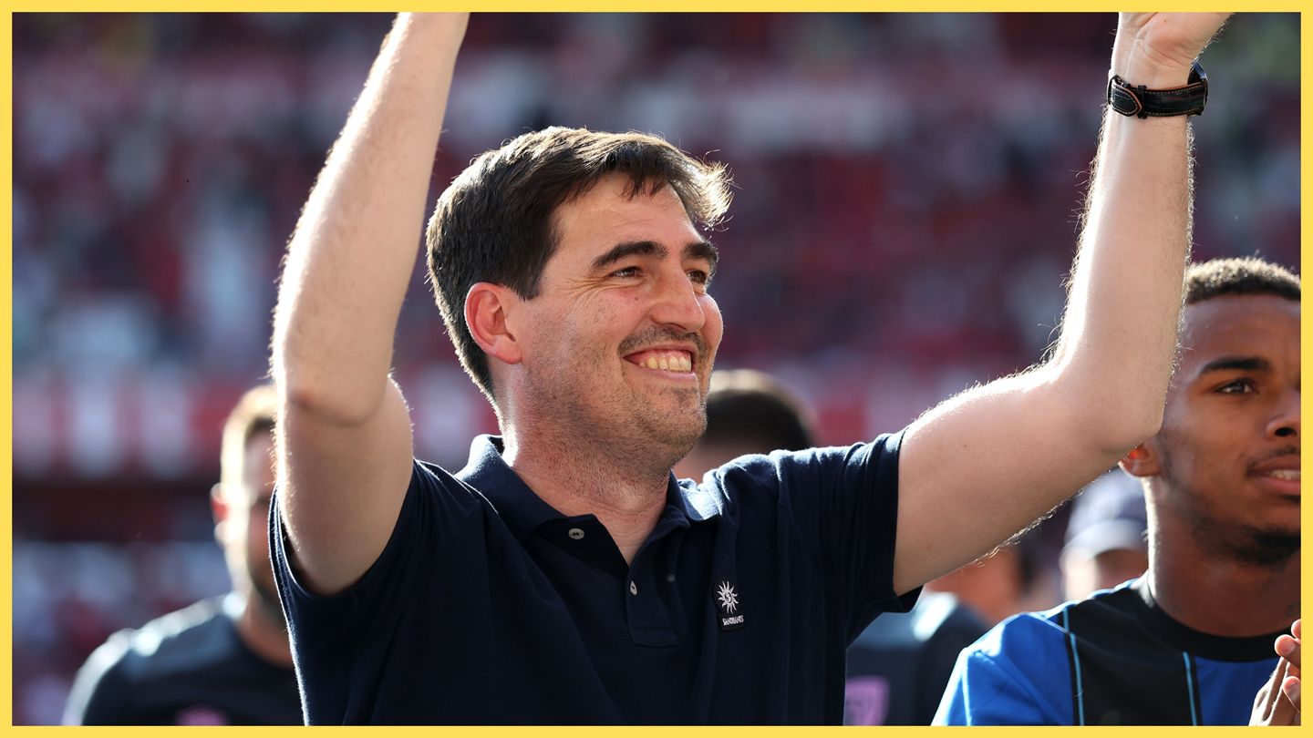 Liverpool manager Andoni Iraola celebrates with his arms in the air.