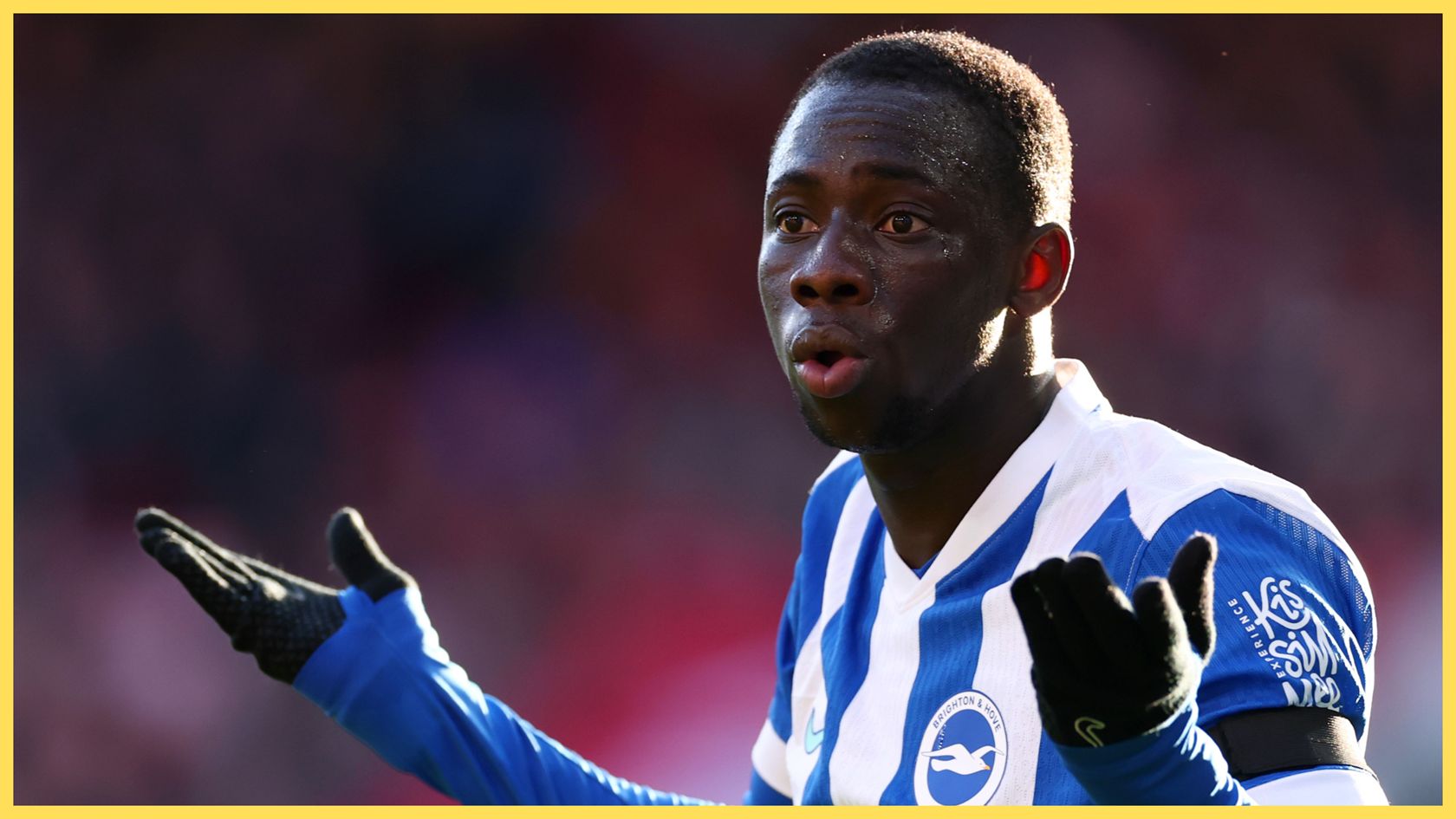 Liverpool transfer target Yankuba Minteh holds up his hands in confusion during Brighton game.