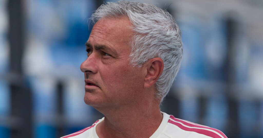 Le manager de football José Mourinho regarde à sa droite tout en portant une chemise blanche avec une bordure rouge clair dans son rôle d'entraîneur-chef du club de football de la Liga, le Real Madrid.