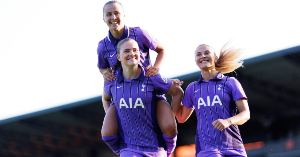 Les footballeurs Victoria Pelova, Signe Gaupset et Amanda Nilden célébrant un but sur un terrain tout en portant le troisième maillot violet de l'équipe de Premier League Tottenham Hotspur Football Club