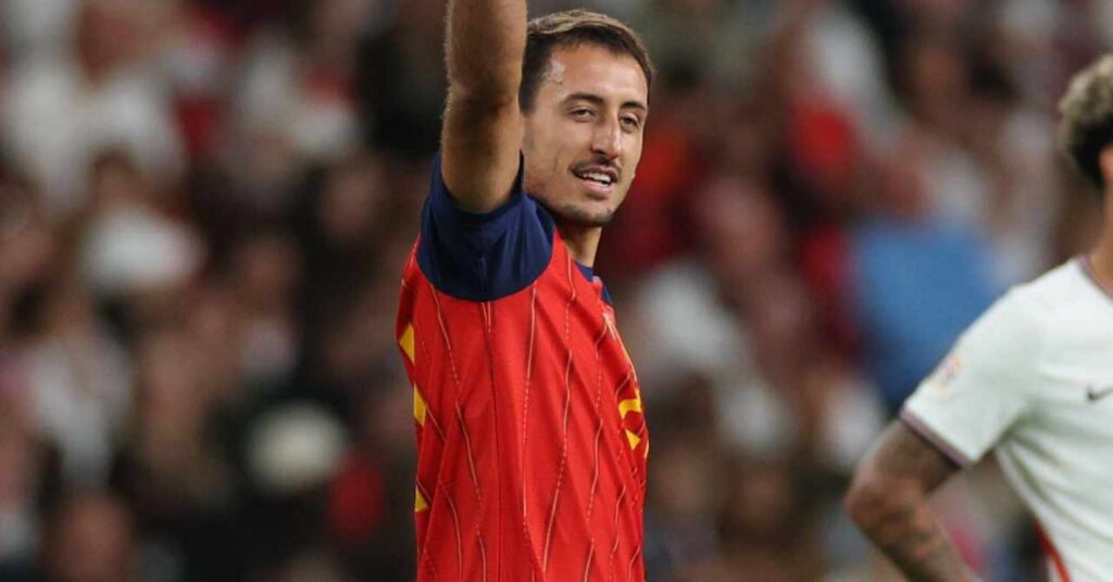 Mikel Oyarzabal, footballeur de la Real Sociedad, de l'équipe de la Liga, lève le bras droit pour célébrer un but alors qu'il joue pour l'équipe nationale espagnole de football dans un maillot rouge avec une bordure bleue et des rayures jaunes