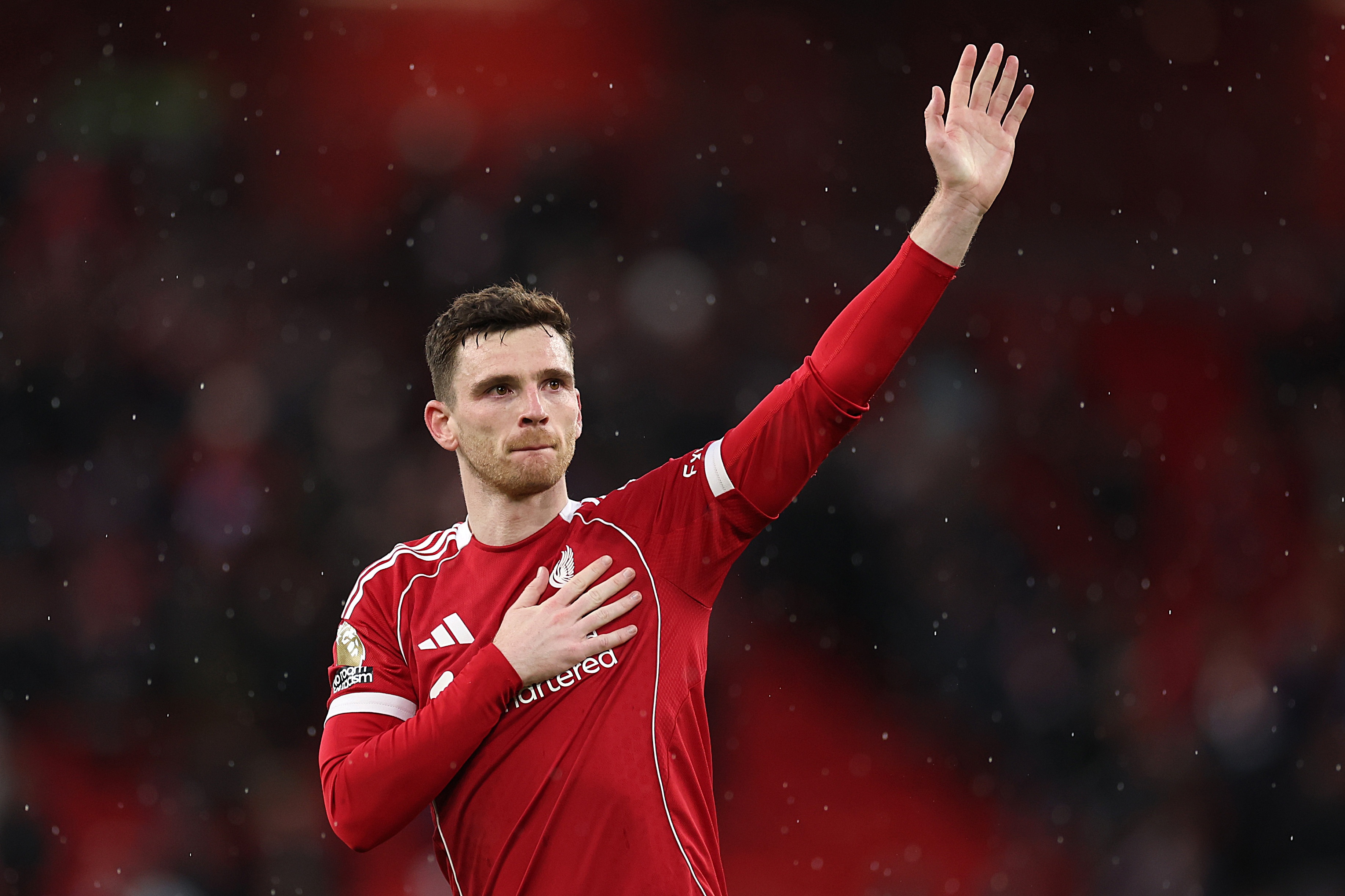 L'ancien arrière gauche de Liverpool, Andy Robertson, lève le bras gauche et tapote le foie sur sa poitrine.