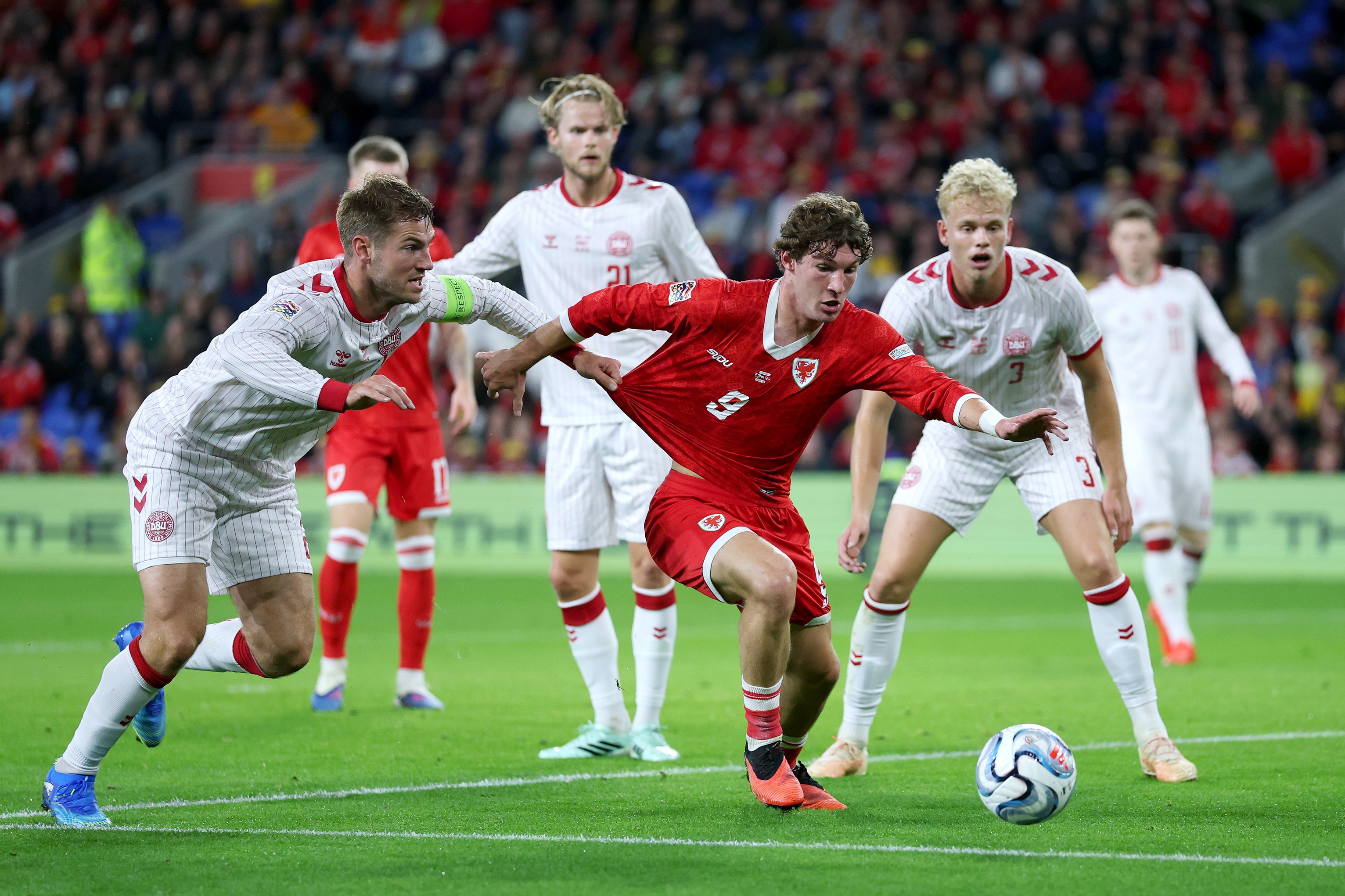 Lewis Koumas dribble sur le ballon sous pression lors du match du Pays de Galles.